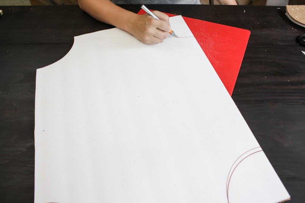 Using a craft knife, cut out curved areas from the corners of the cork board. 