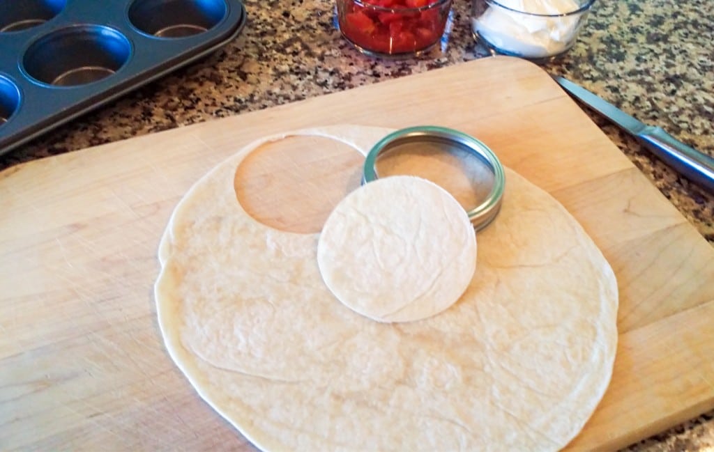 The first step of this easy taco cups recipe is to cut out mini tortillas. Fun!