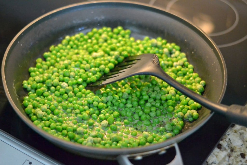 Toss the peas in the frying pan and coat with the butter. 