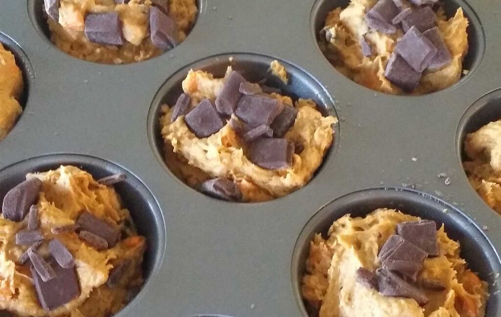 Spoon pumpkin muffin batter into cupcake tin and top with chocolate chunks. 