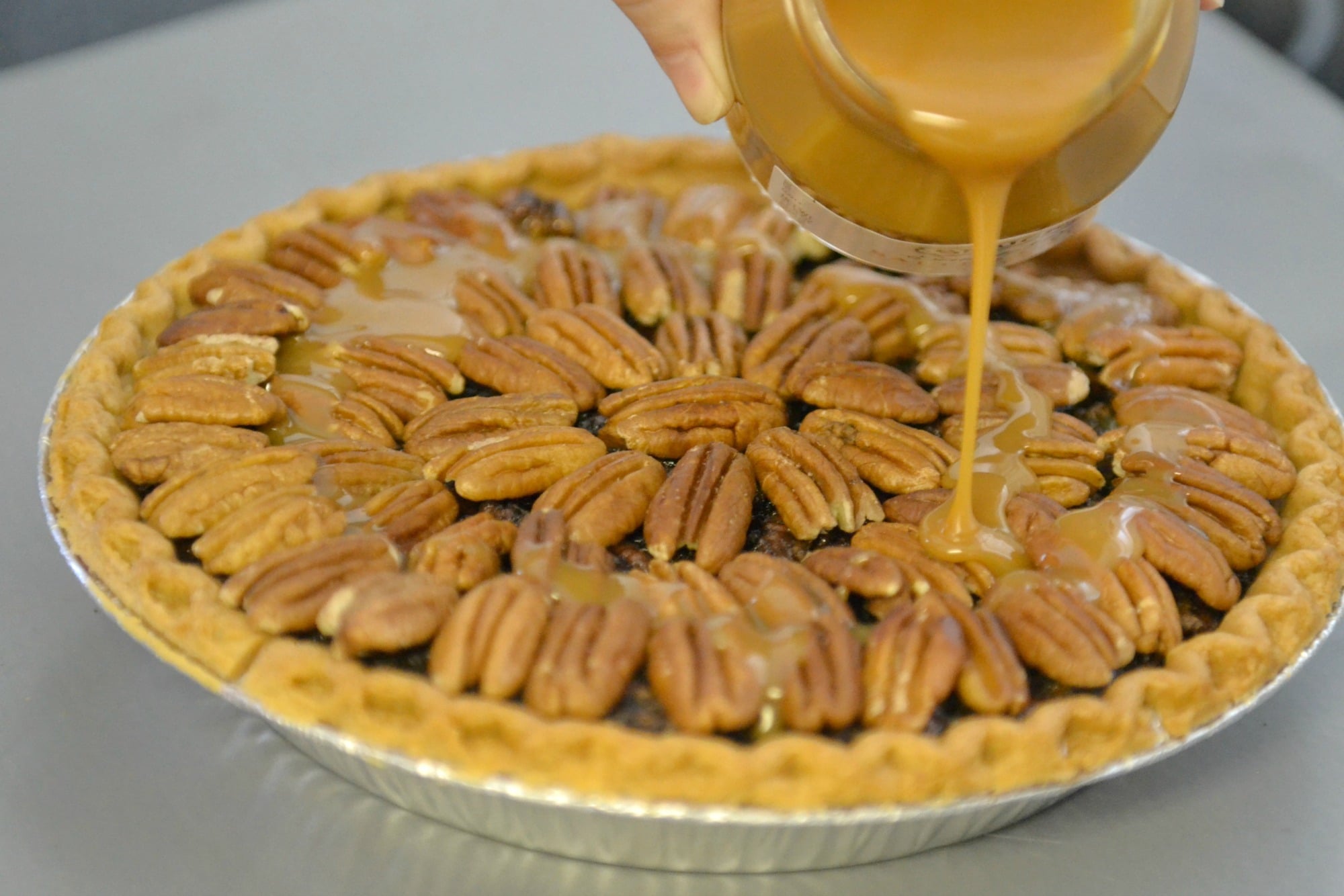 Top the pie with pecans and a salted caramel drizzle