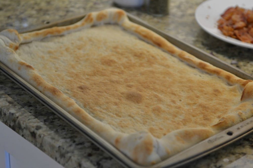 Bake pizza crust until golden brown. 