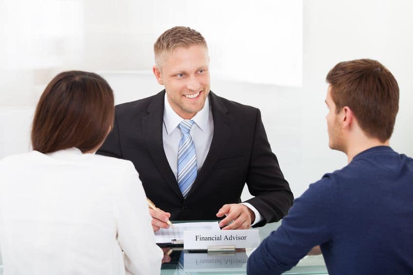 A professional financial adviser assists a couple.