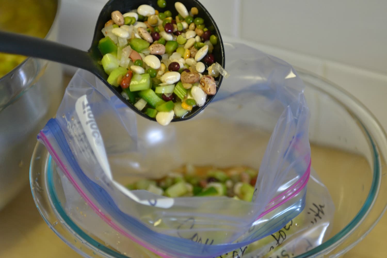 Use a ladle to spoon the Cajun bean soup into pre-labeled freezer bags. 