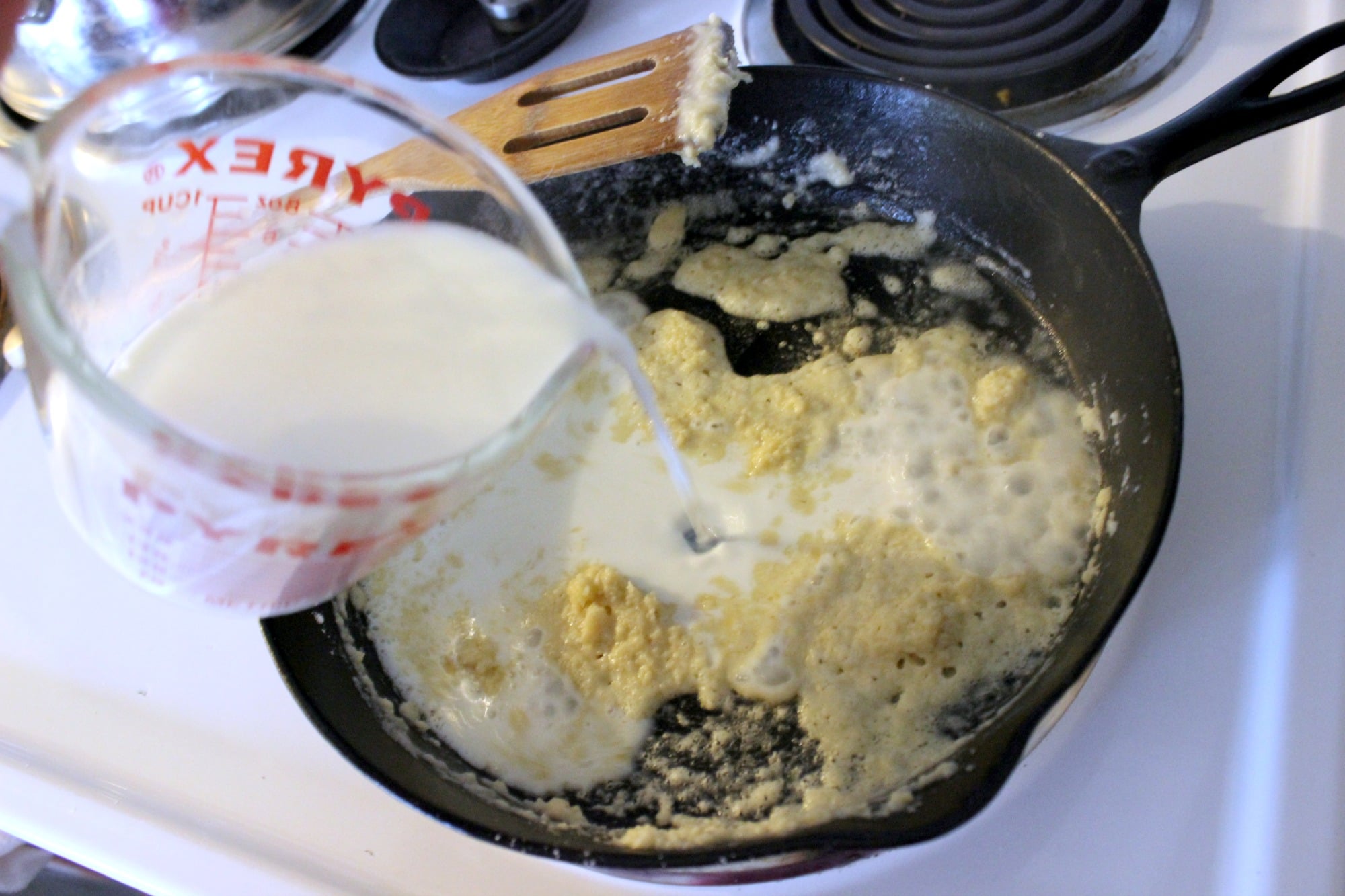 Pour in one cup of milk to thick flour paste. 