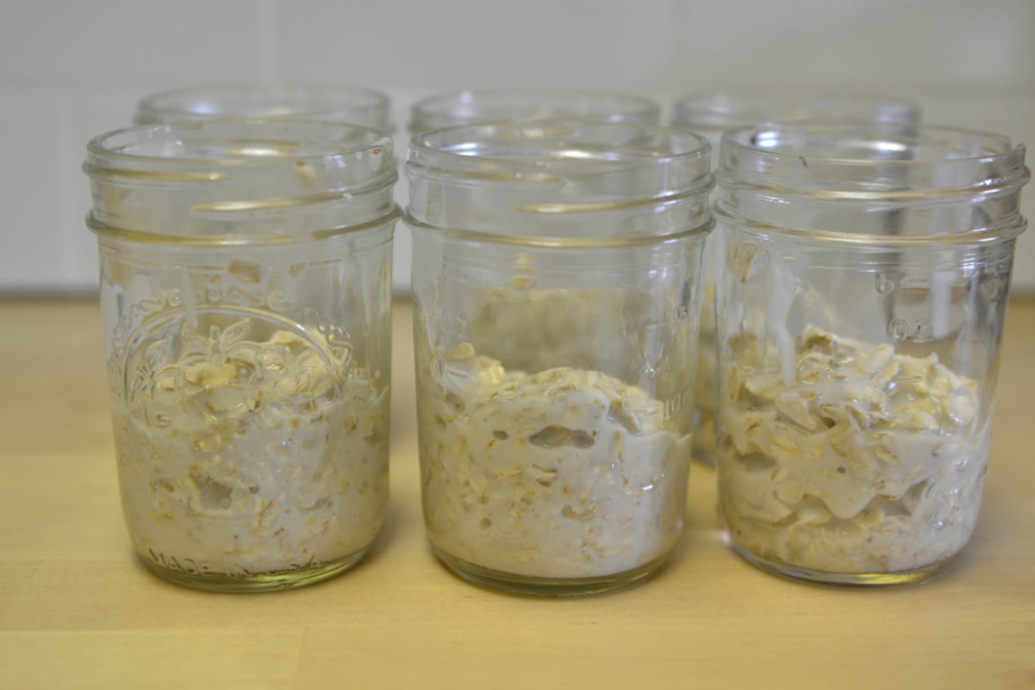 Spoon oatmeal and yogurt mixture into mason jars