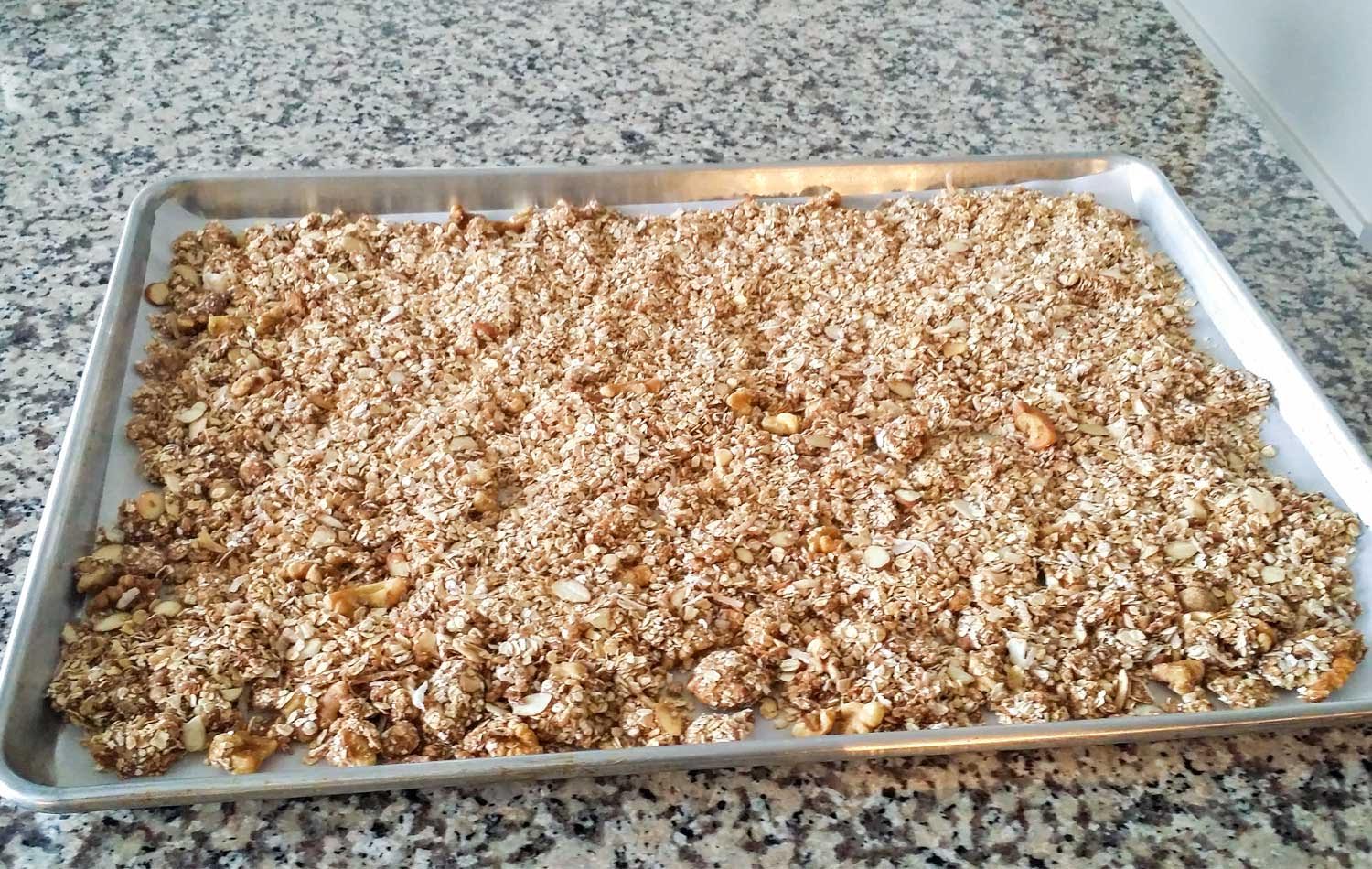 Transfer granola mixture to a cookie sheet lined with parchment paper. 