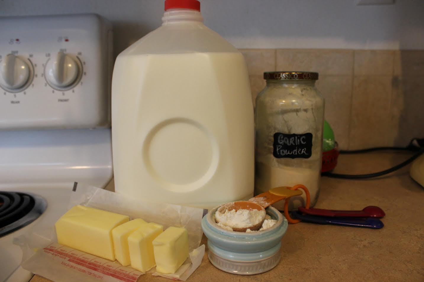 Assemble your ingredients for the cream of chicken soup: butter, flour, milk and garlic powder. 