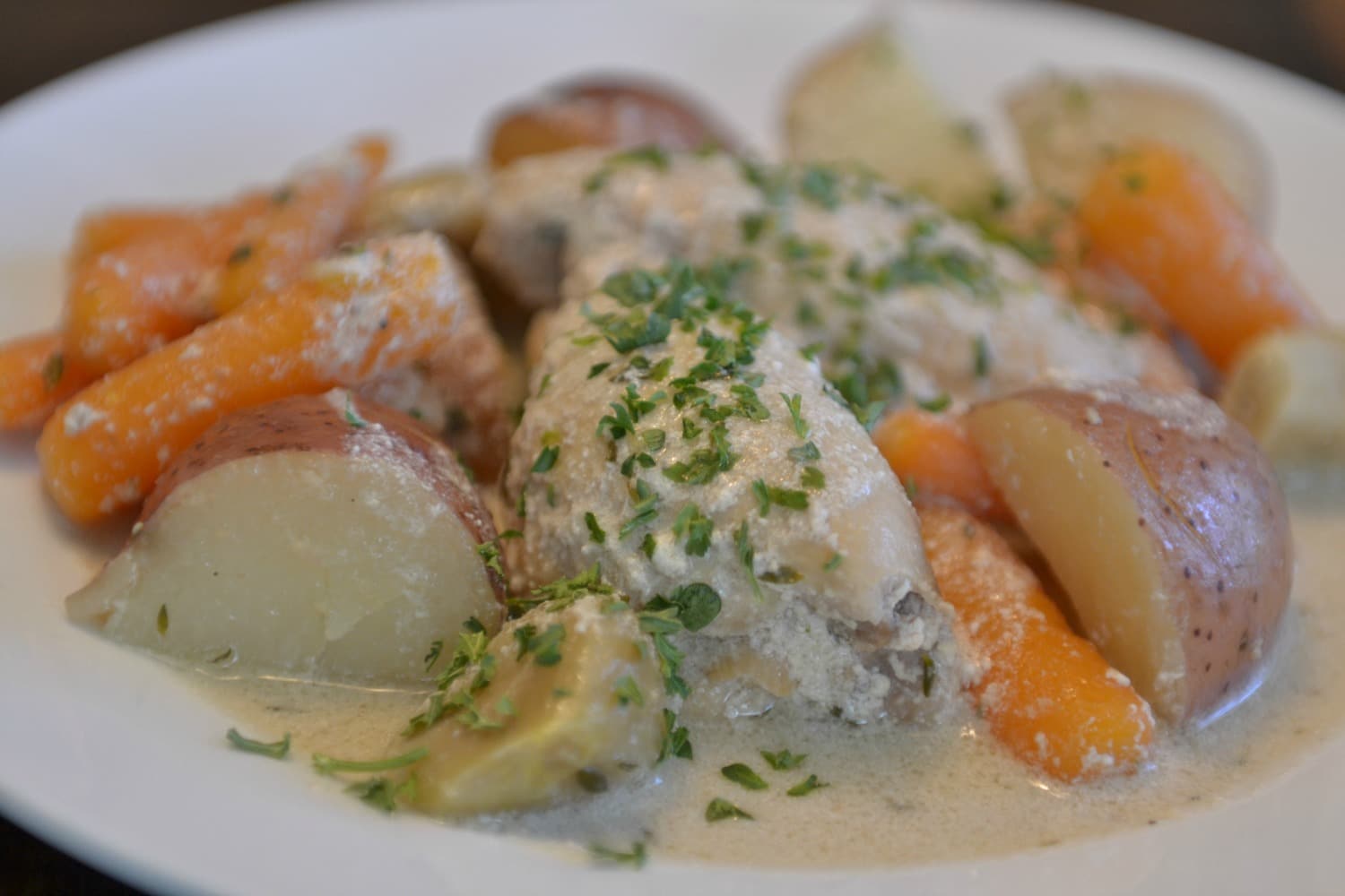 Once cooked, serve garlic chicken with baby carrots and baby potatoes on a plate and enjoy. 