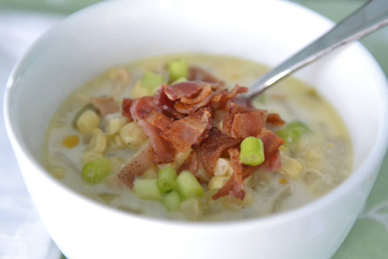 Serve finished corn and clam chowder soup with green onions and crispy bacon. 