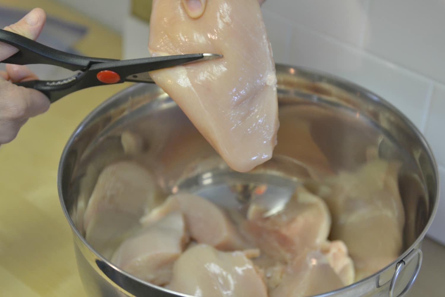 Cut chicken breasts in halves then place into bowl. 