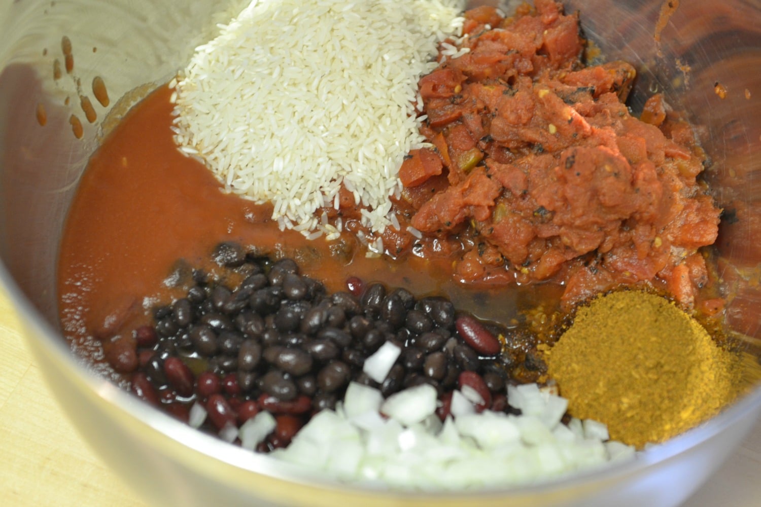 Mix together tomato sauce, beans, seasonings, and rice in a large bowl. 