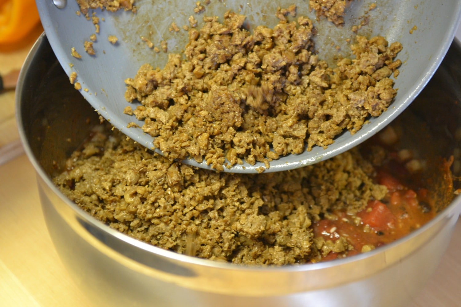 Add the ground beef or vegetarian crumbles into the sauce mixture. 