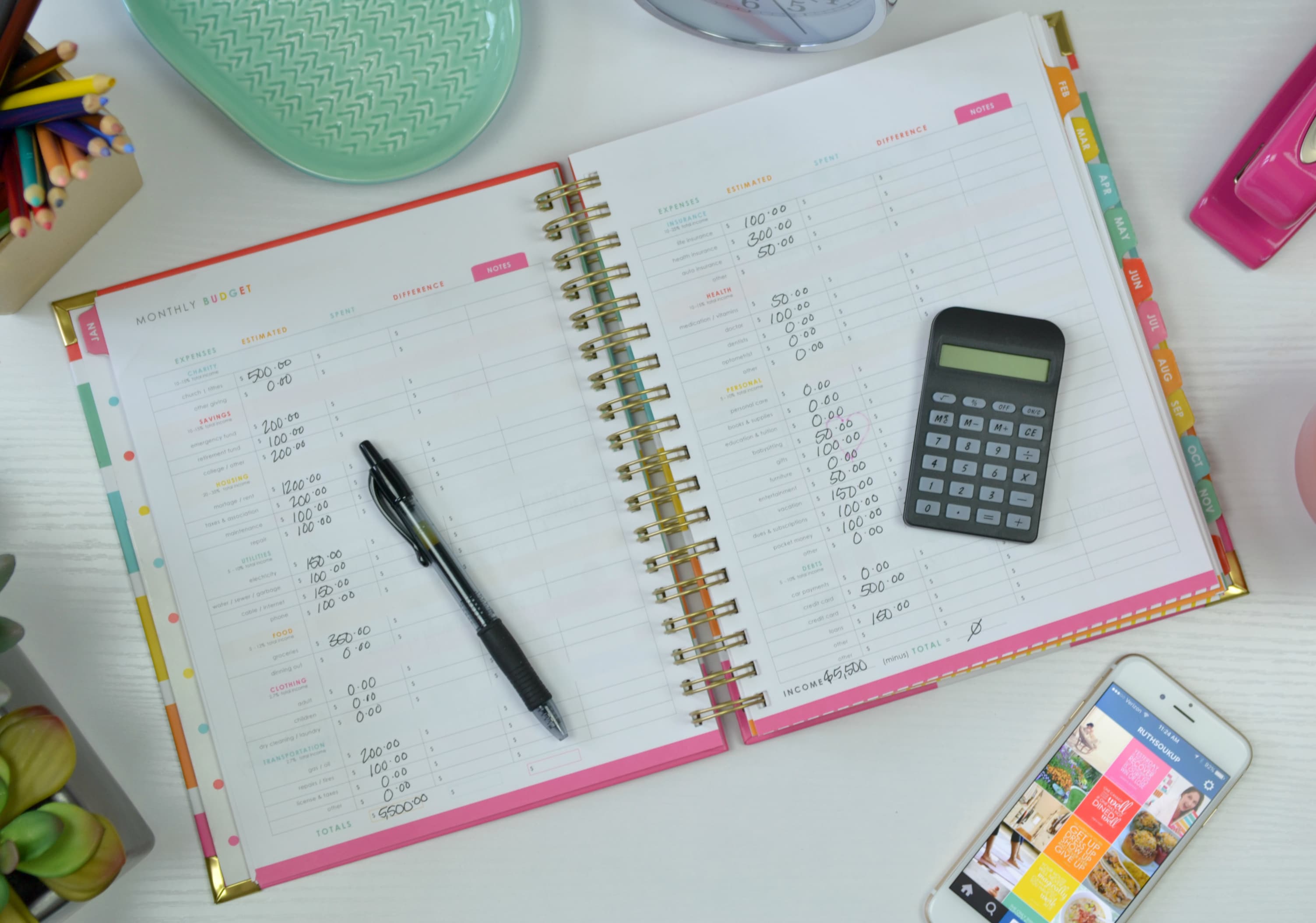 Track your expenses in a personal journal using a calculator and pen. 