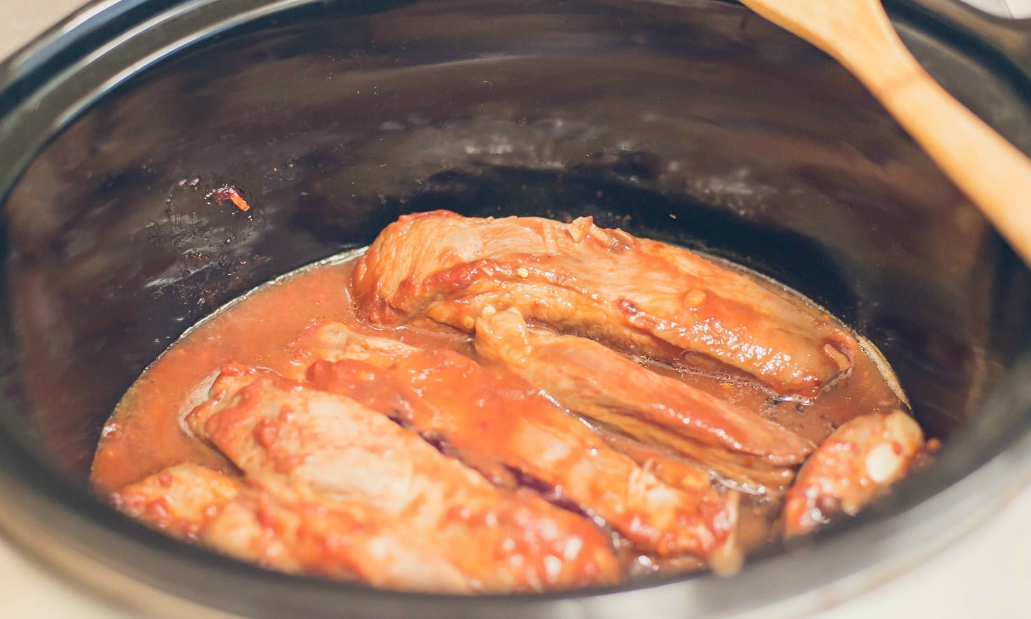 Defrost and toss the ribs in the slow cooker, set to high until cooked