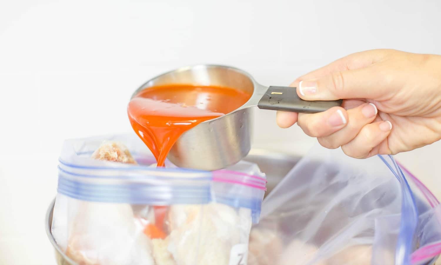 Pour the buffalo sauce right over the chicken wings inside freezer bags. 