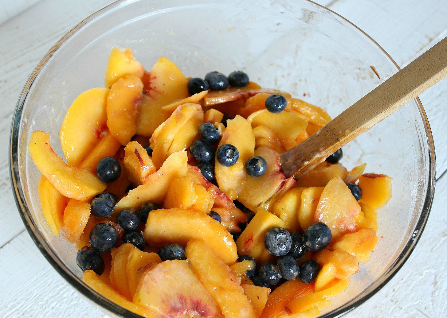 In a bowl, slice the peaches, add the blueberries and combine with the starch and lemon juice, stirring to coat. 
