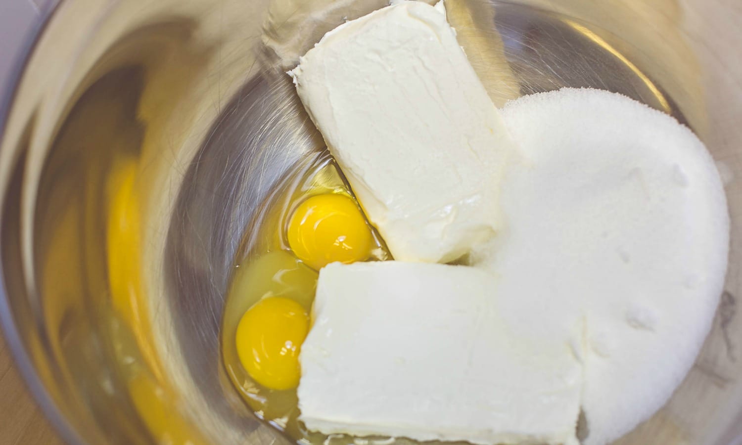 The next step for the easy Mini Cheesecakes is to mix the eggs, cream cheese, sugar and lemon extract/oil.