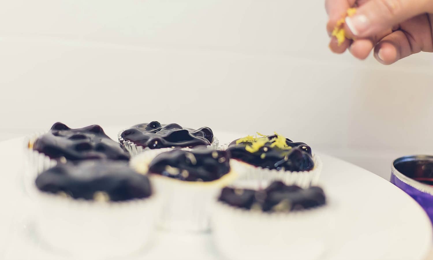 The final touch on the easy Mini Cheesecakes is topping with pie filling and lemon zest, yum! 