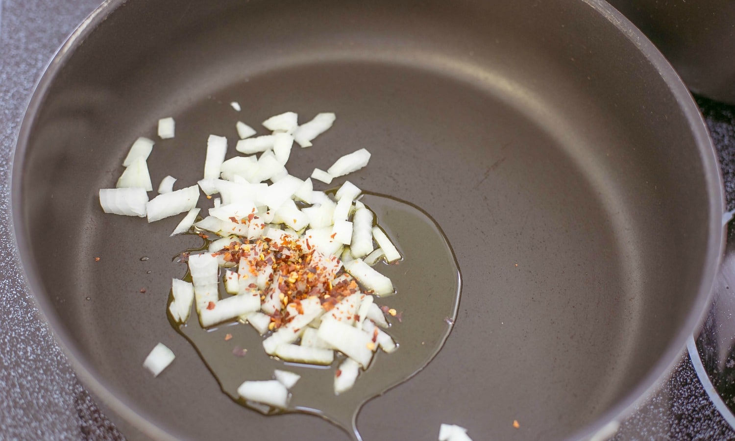 The next step is to sauté the onion and red pepper flakes in olive oil for the One Pot Pasta and Clam Sauce.