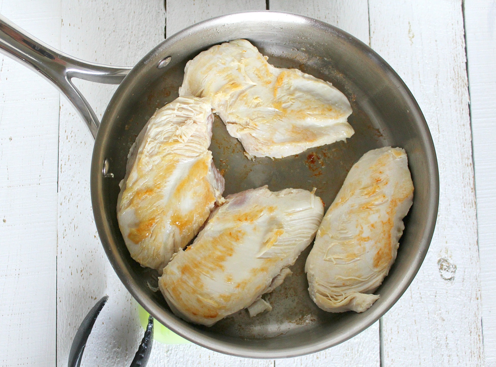 Using a large, greased skillet, brown the chicken breasts. 
