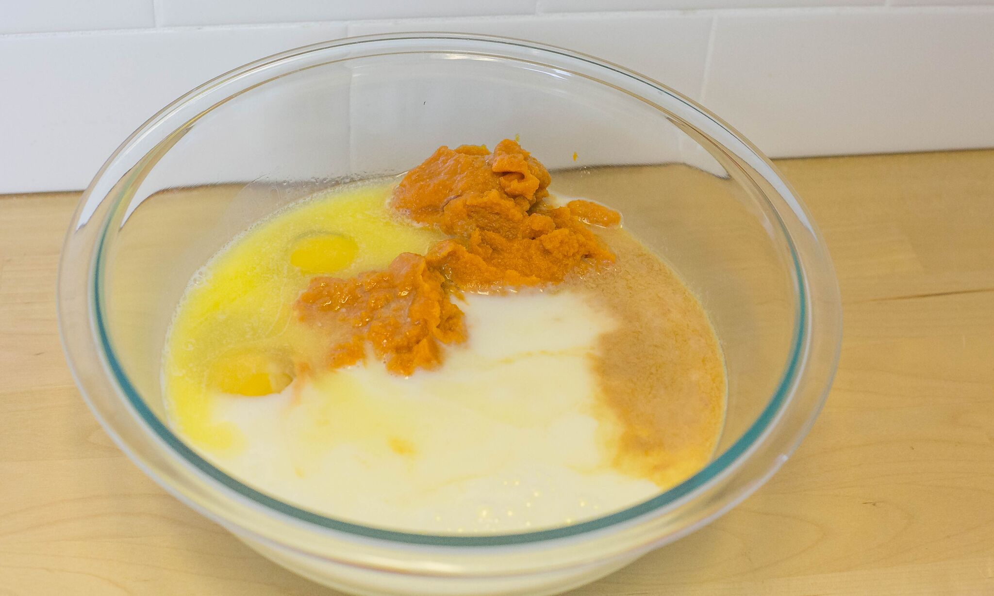 n a separate bowl, beat eggs, melted butter, milk, vanilla extract and pumpkin puree until well blended.