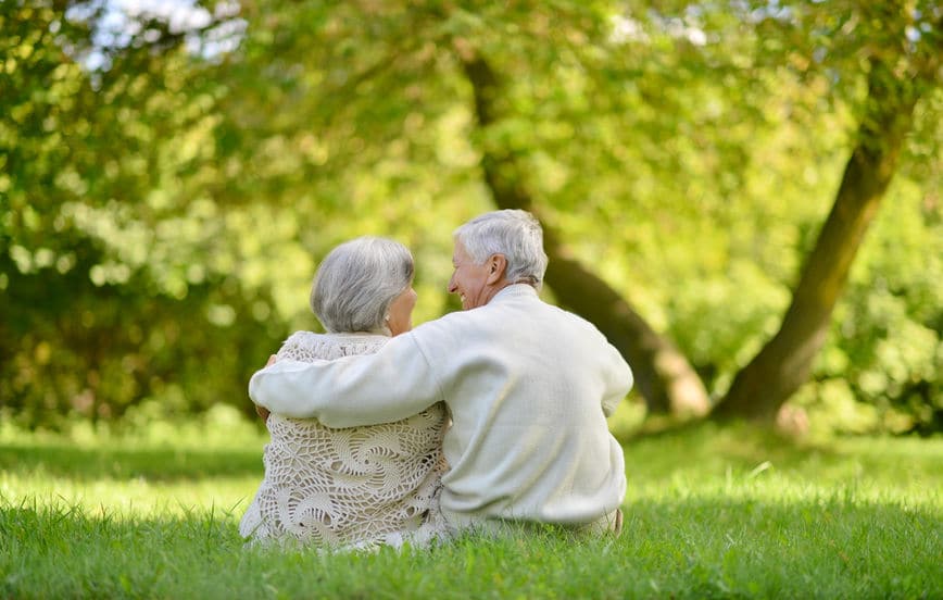 This happy elderly couple in the park is excited for their future. 