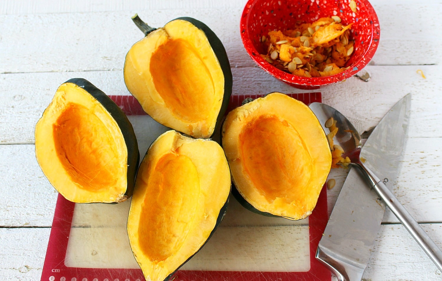 Remove seeds of acorn squash with spoon. 