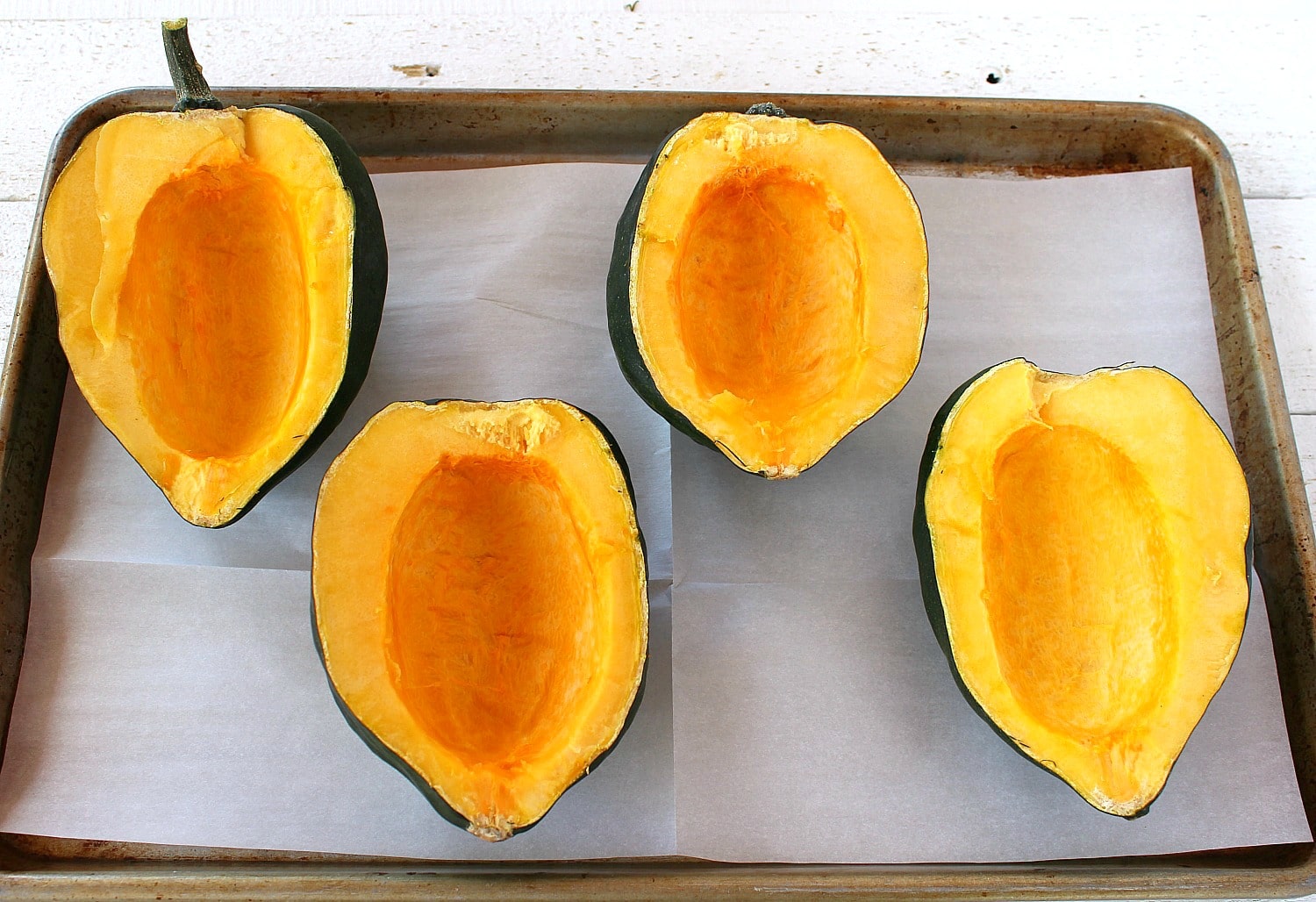 Place each squash flesh side up on cookie sheet with parchment paper. 