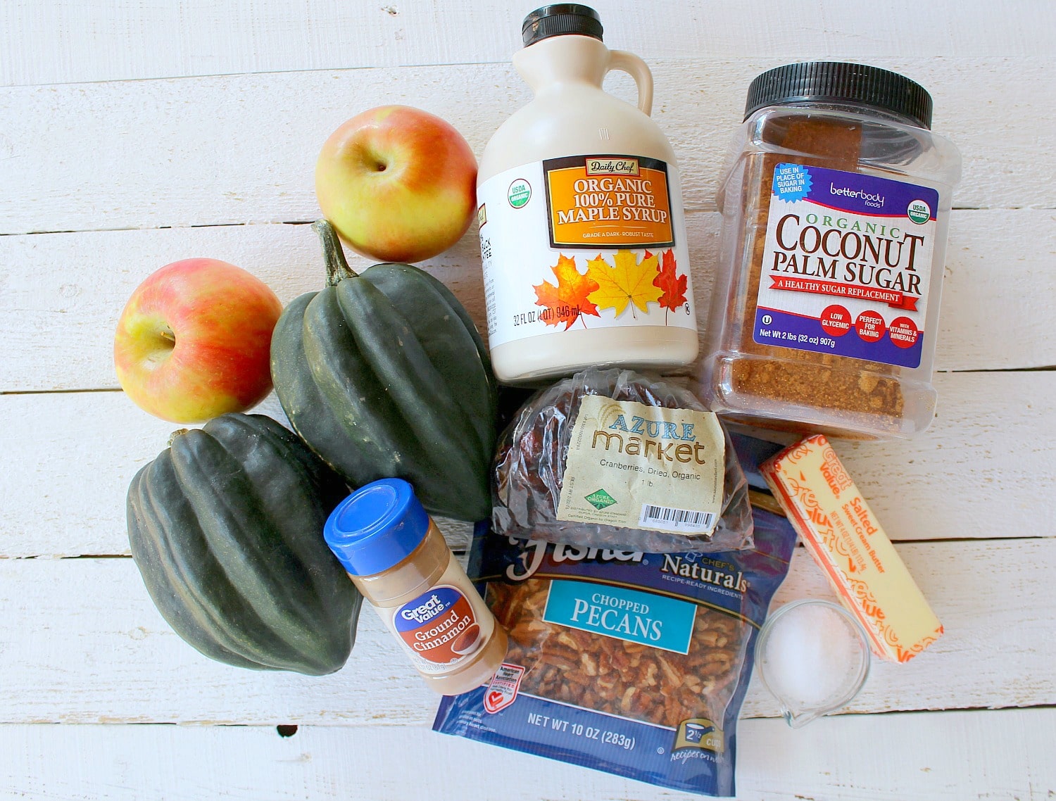 Assemble your ingredients: Acorn squash, apples, pecans, dried cranberries, coconut sugar, butter, maple syrup, cinnamon and salt. 