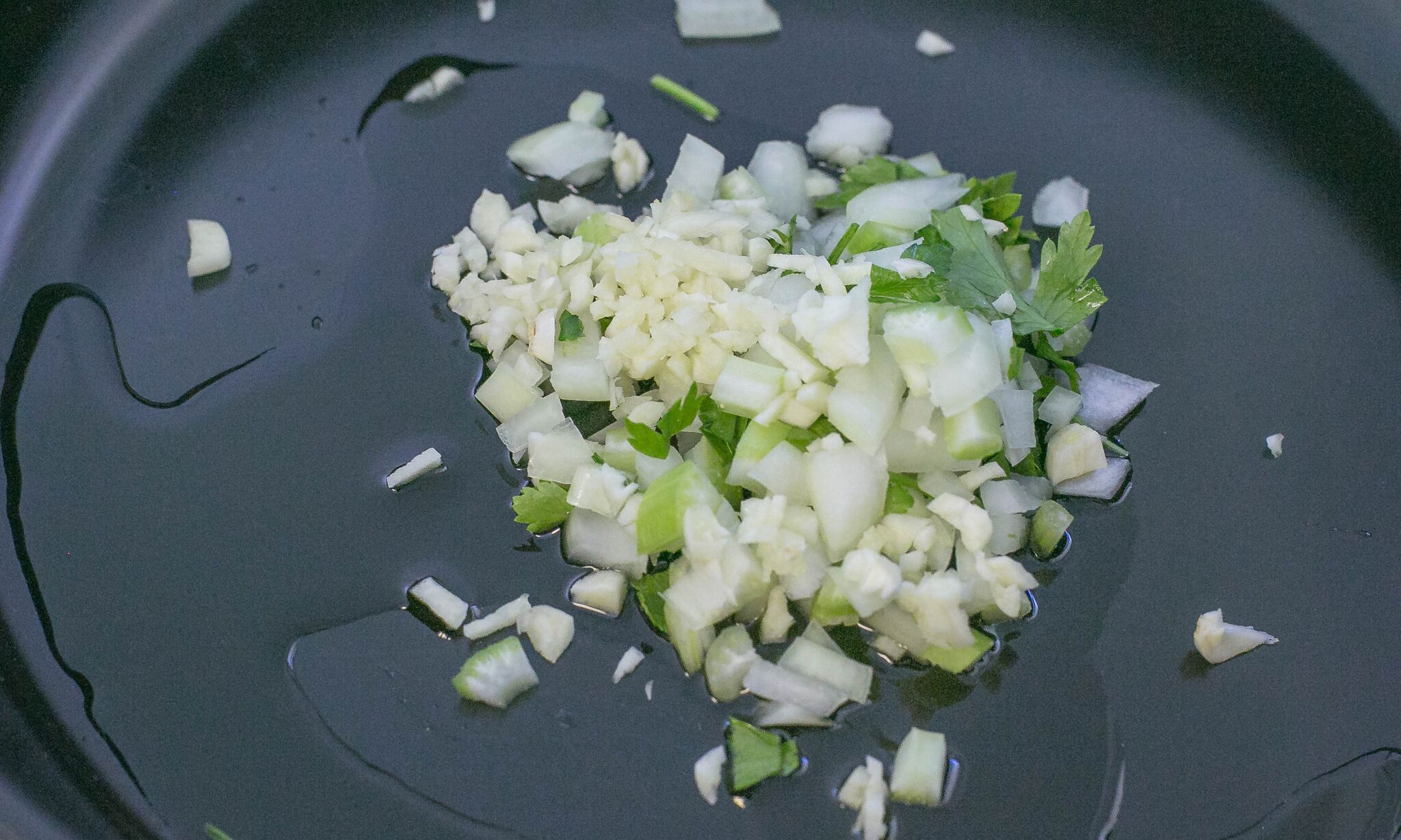 dd 2 tablespoons of oil to large frying pan. Then saute 1/2 cup of onion and 2 tablespoons garlic with pinch of parsley.