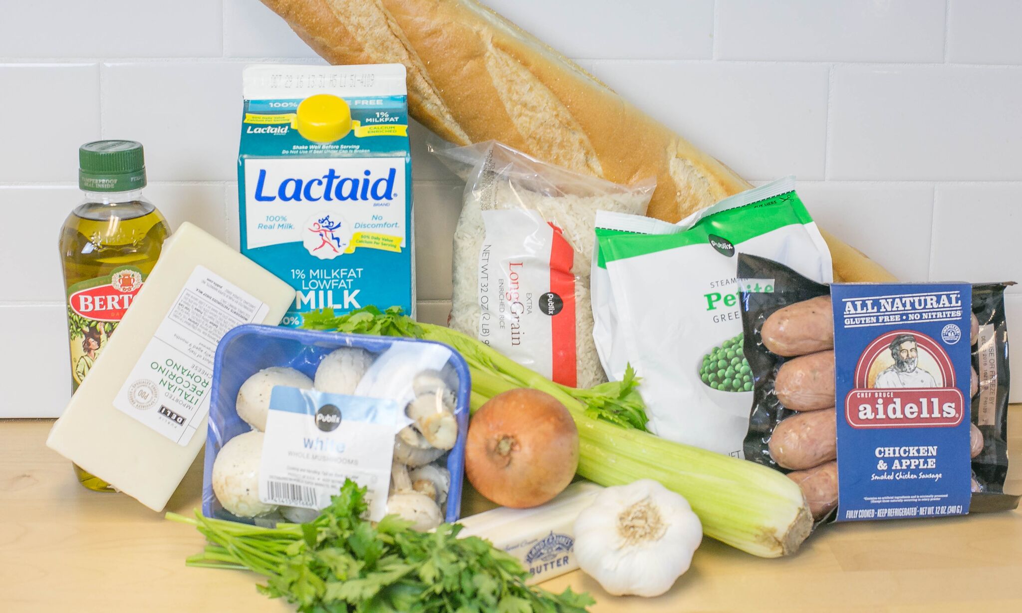 Assemble your ingredients for the rice stuffing: Milk, olive oil, cheese, mushrooms, onions, garlic, frozen peas, rice, bread, sausage, celery, butter and fresh parsley. 