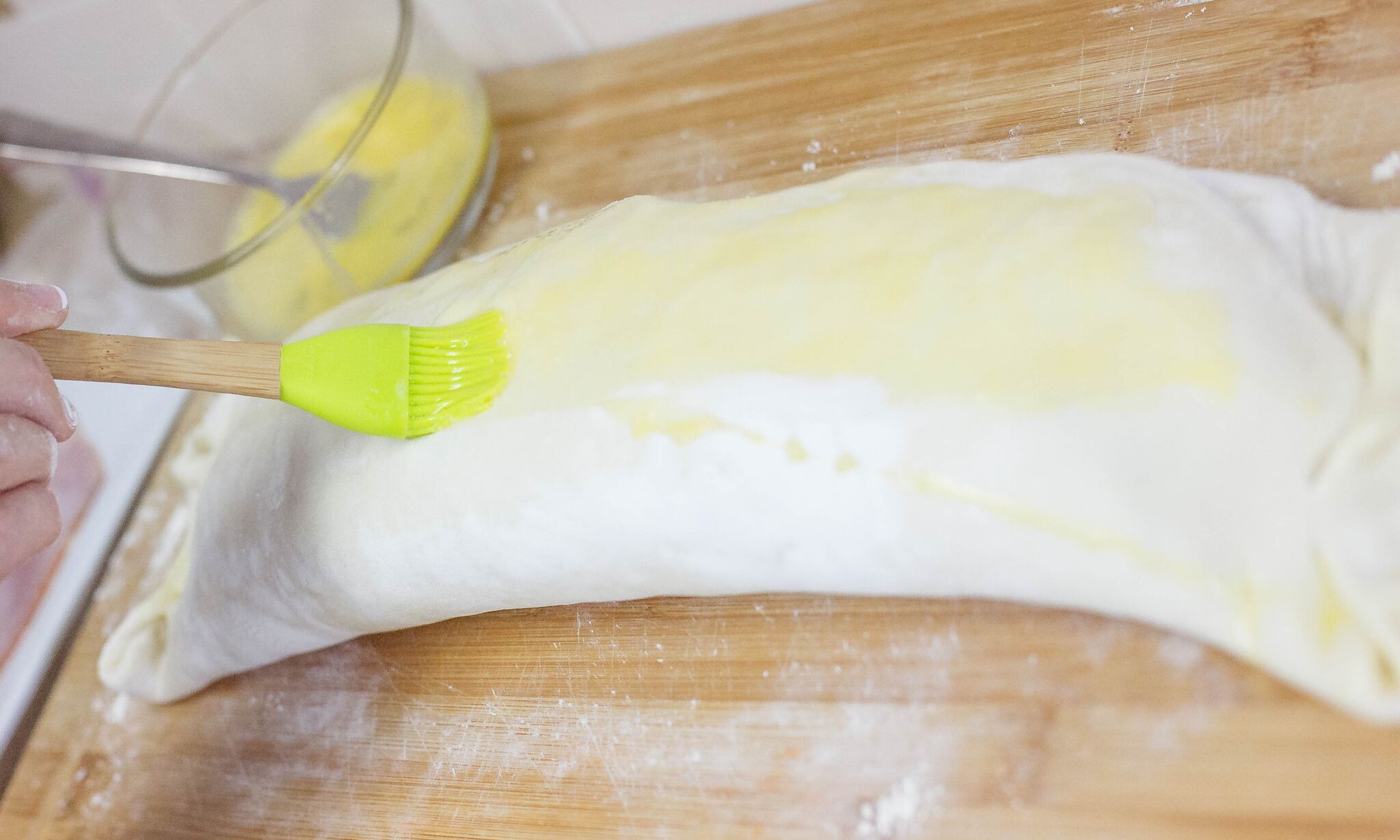 Using a pastry brush, brush the top of the stromboli with egg wash then sprinkle with Italian seasoning. 