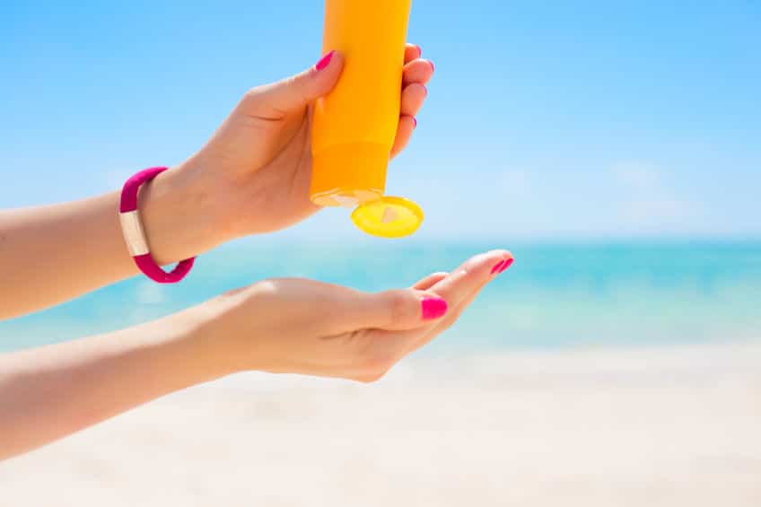 Woman uses sunscreen to protect her skin. 