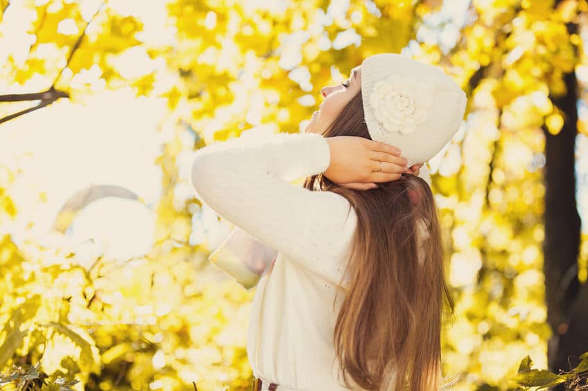 Young woman wearing a hat soaks up the sun and the great outdoors. 