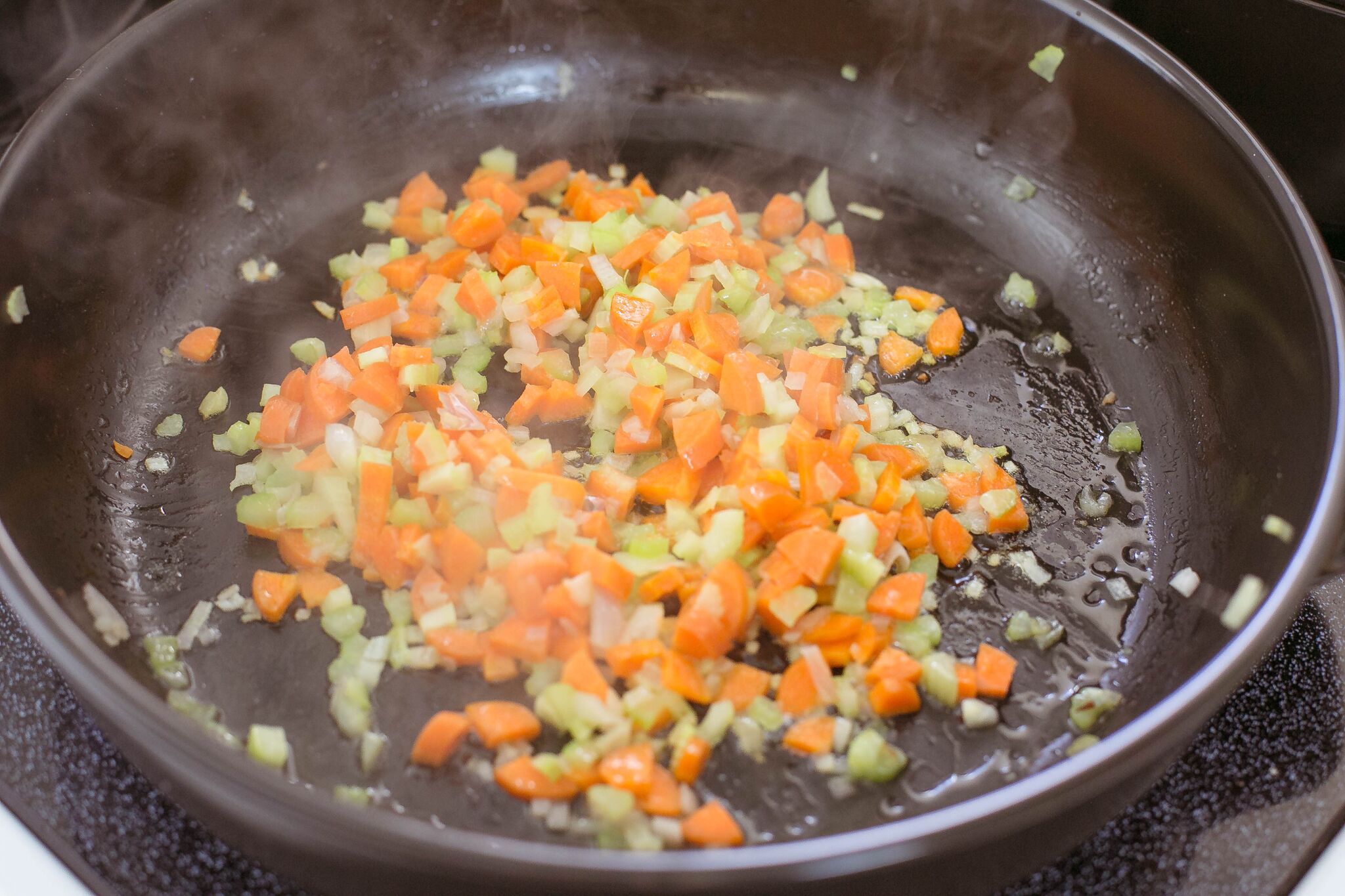 Melt butter in a saucepan over medium-high; add shallots, carrot, and onion and cook. 