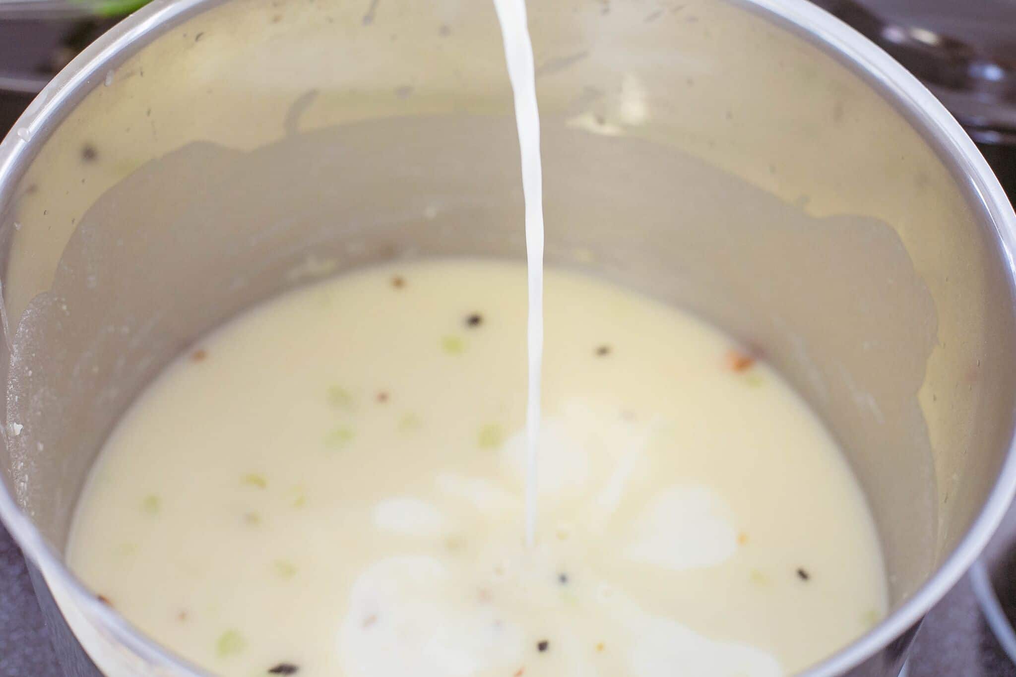 Add stock, milk, a pinch of salt and pepper to pot then stir. 