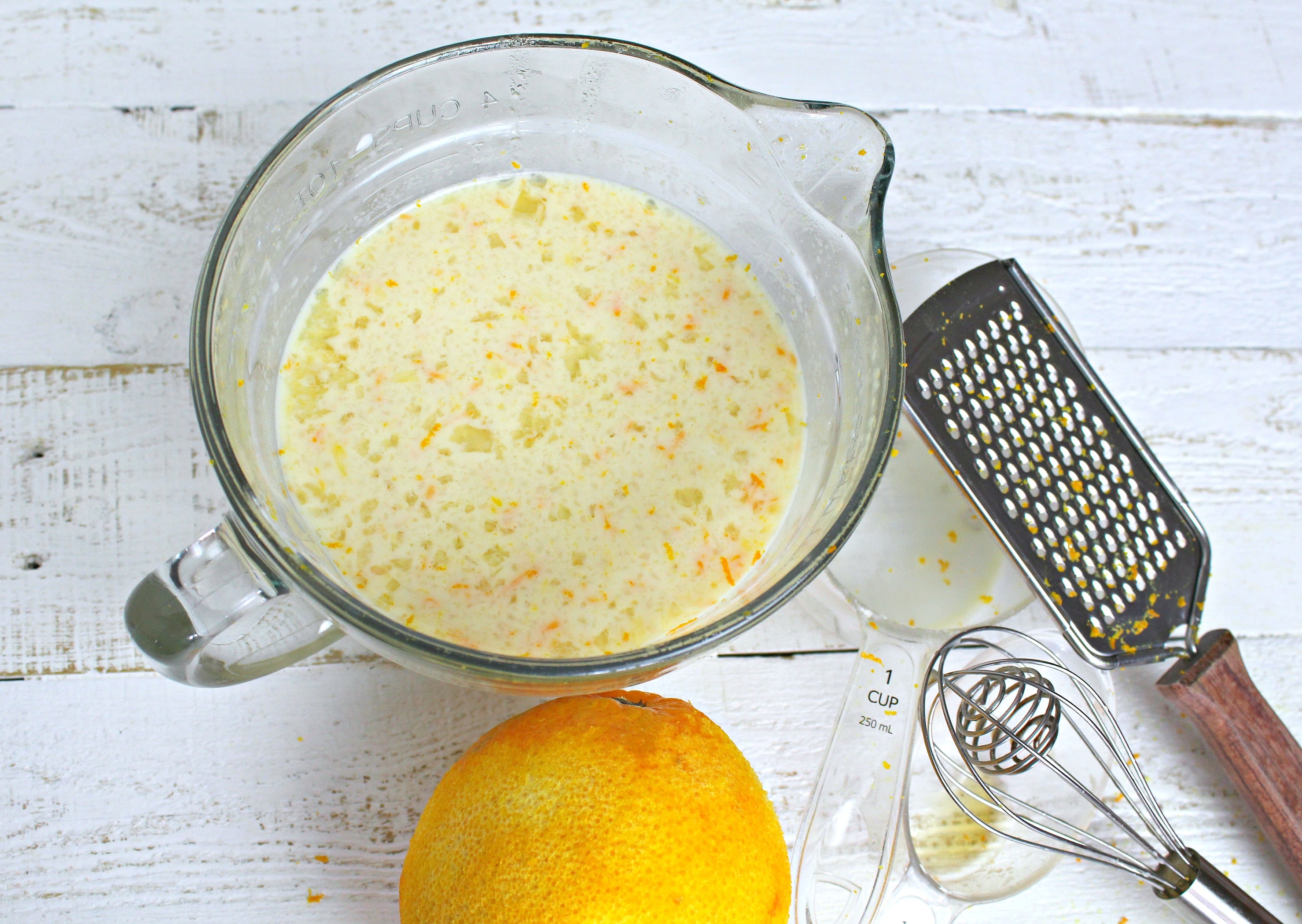 In a medium-sized bowl, whisk together milk, maple syrup, eggs, applesauce, vanilla, and the zest of the orange.
