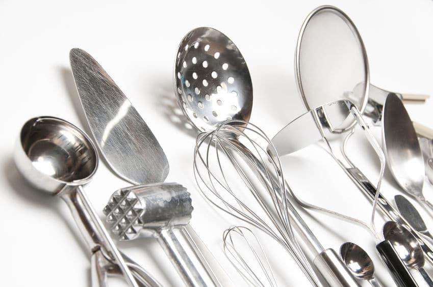 Various kitchen utensils including a whisk, strainer and masher. 