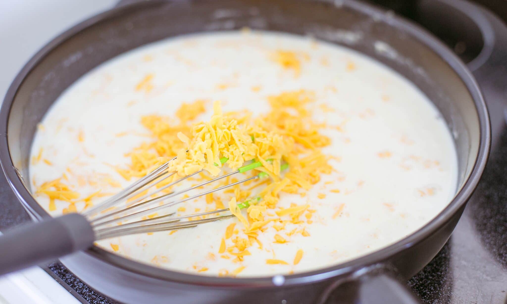 Slowly add milk and cheese to the butter and flour mixture. 