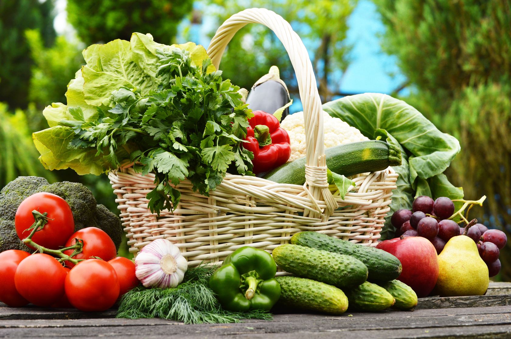 A basket of vegetables on an outside table. 