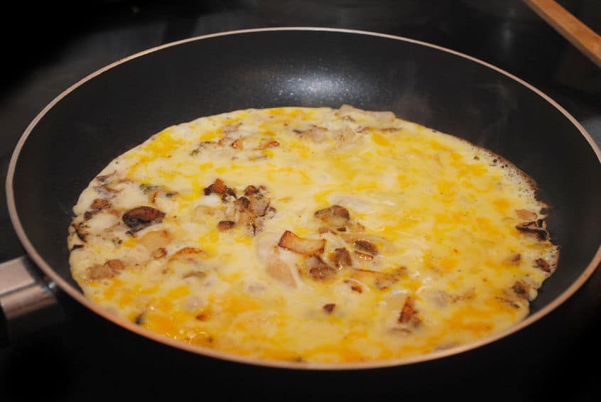 An omelet cooking in a non-stick pan. 