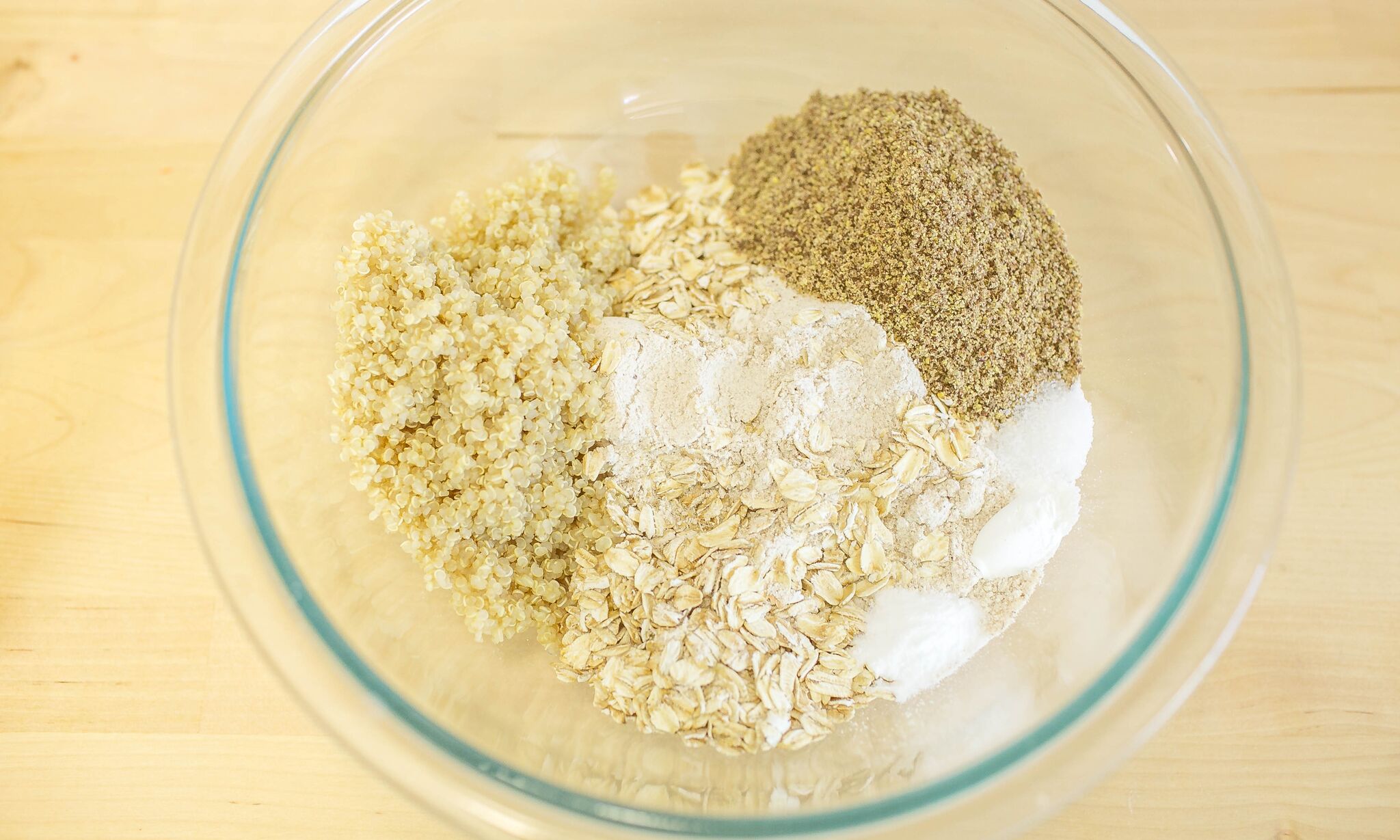 In a medium bowl mix together flour, oats, quinoa, flax seed meal, baking powder, baking soda and salt .