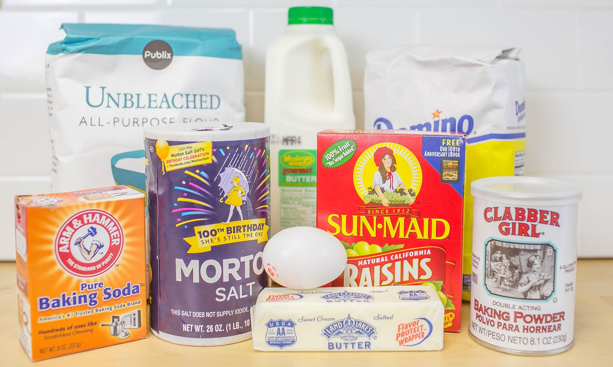 Ready to make Irish soda bread? Here are the ingredients: flour, buttermilk, sugar, salt, raisins, eggs, butter, baking powder and soda.