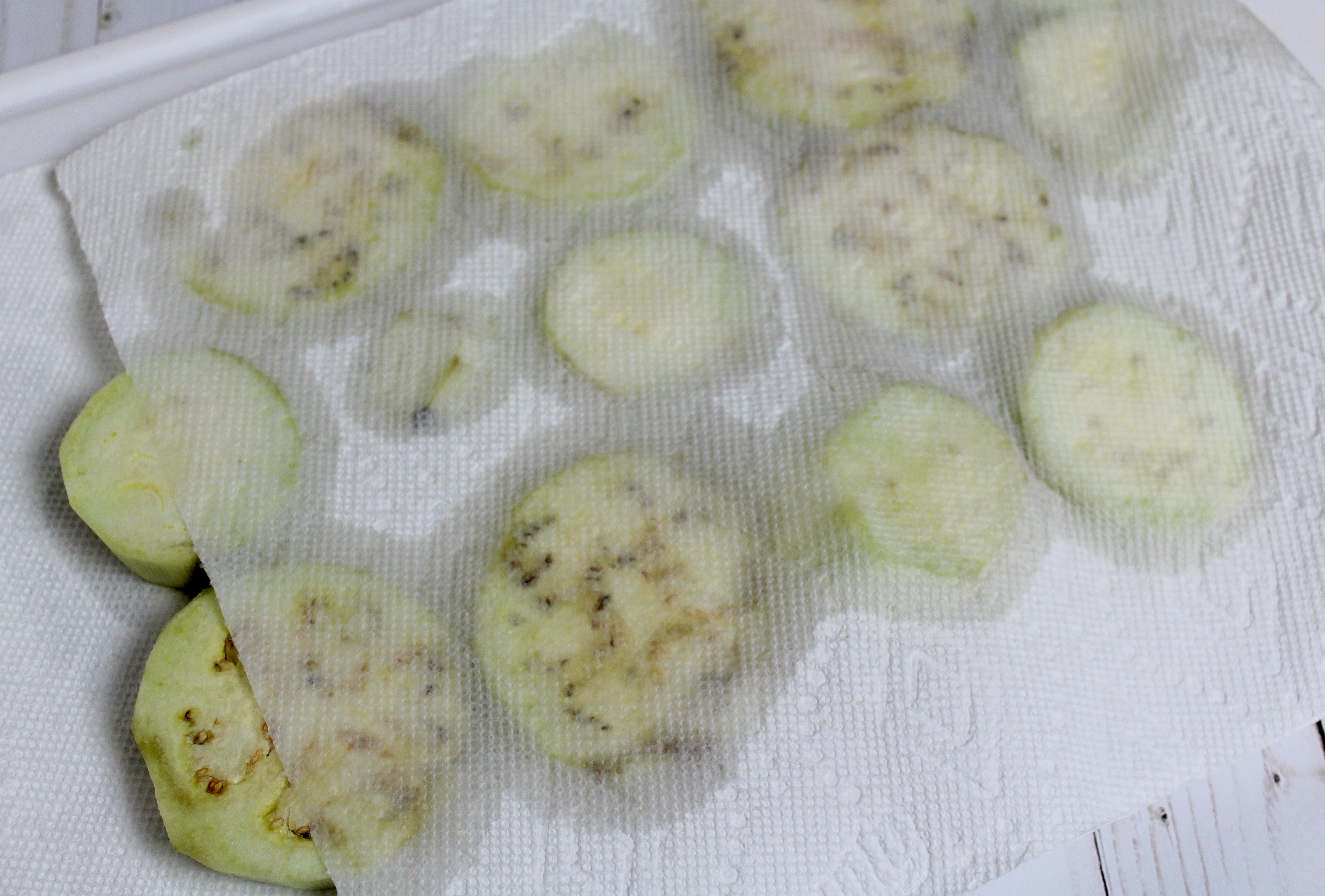 Pat eggplant slices dry of excess water. 