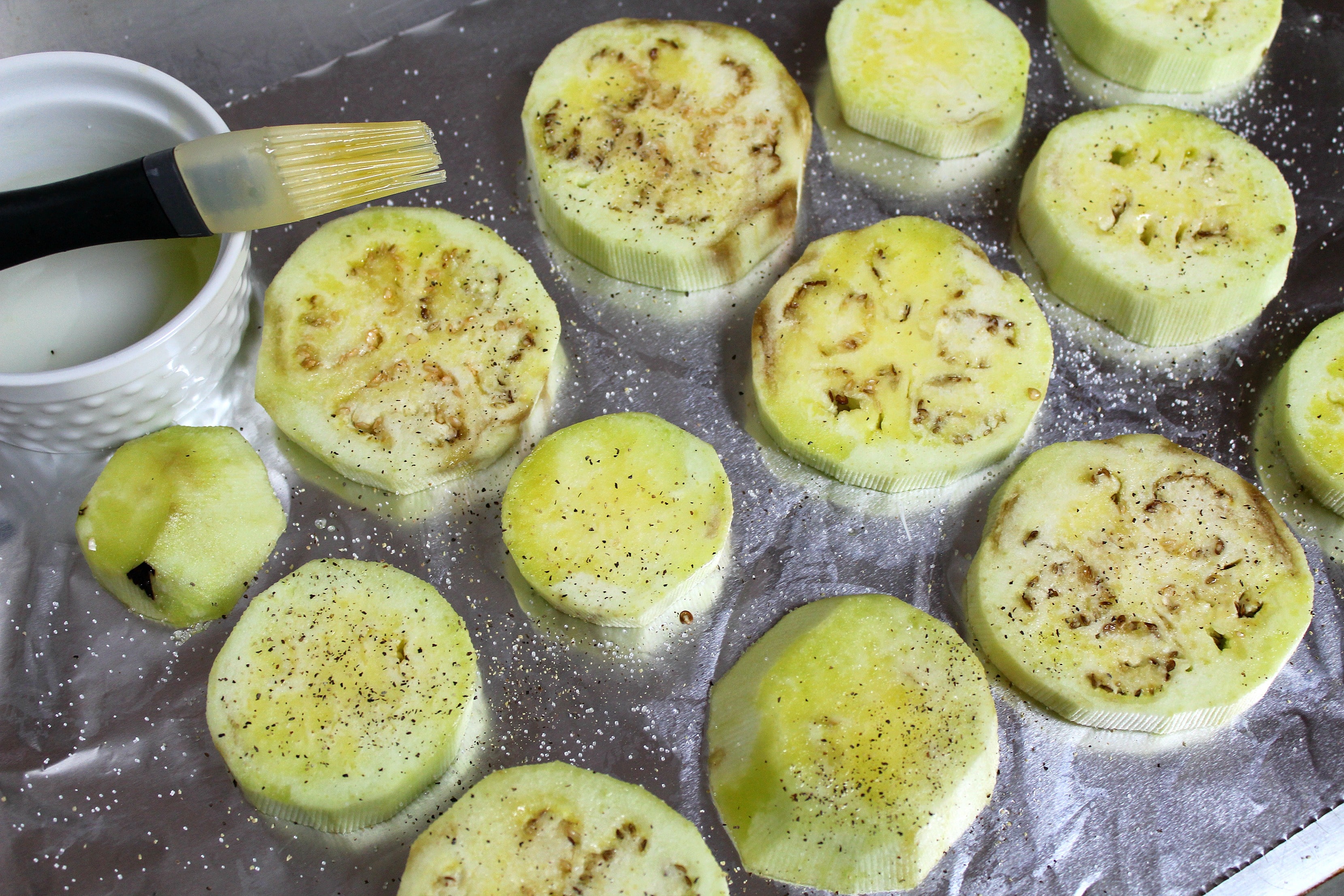 PLace eggplant slices on baking sheet. Brush with olive oil and sprinkle with salt and pepper.