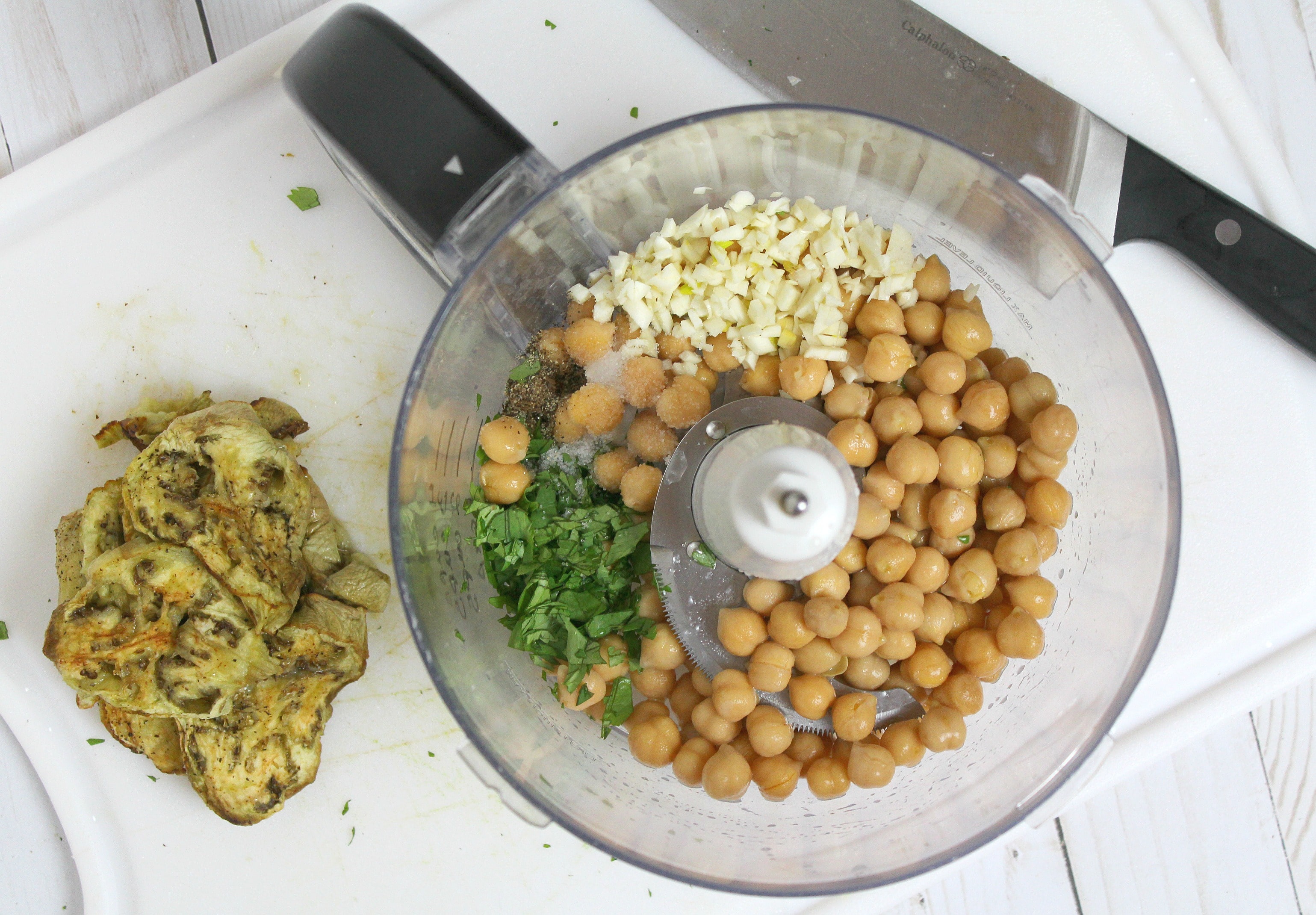 Add chickpeas, garlic, and other ingredients to a food processor and blend for a few seconds, until smooth. 