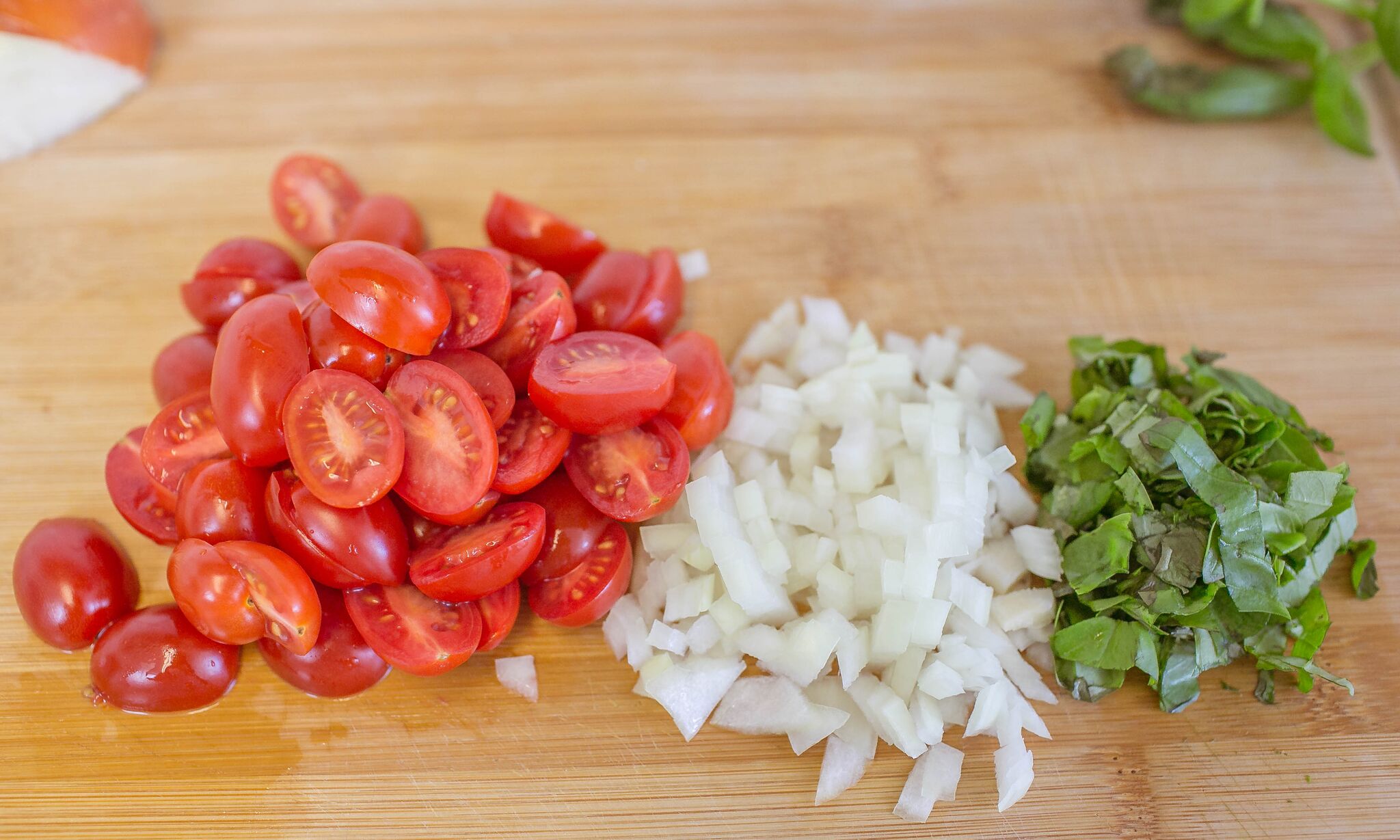 Dice onion, slice tomatoes, and chop basil then set aside.