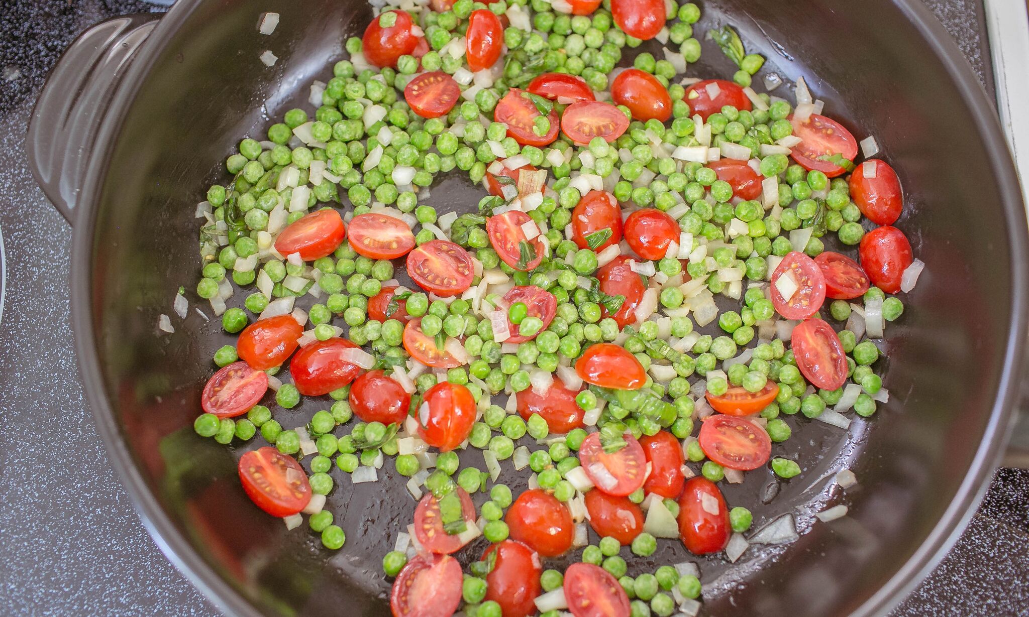 In large saucepan add butter, tomatoes, peas, basil and chopped onion. 