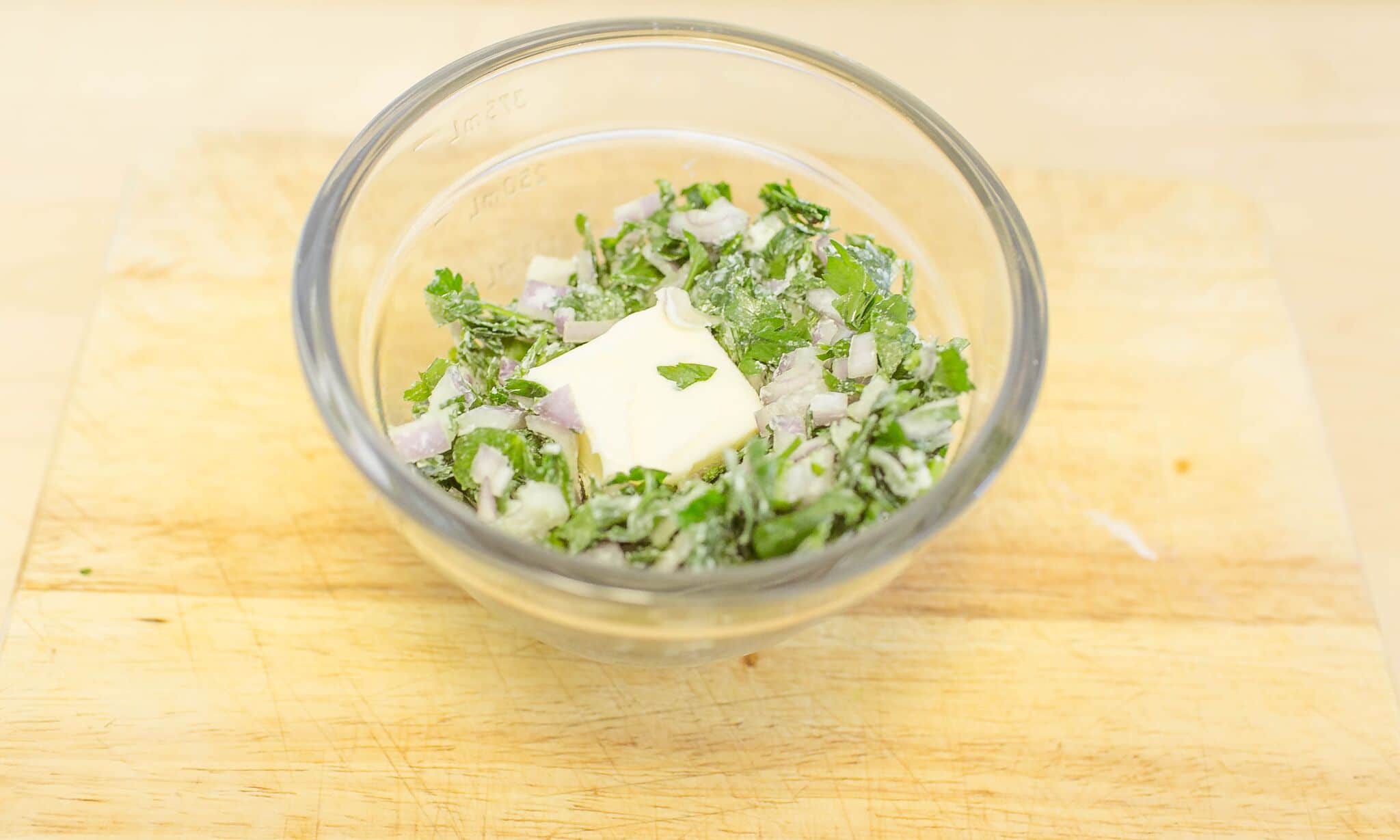 n a measuring cup add the butter, chopped parsley and chopped shallot and mix well.